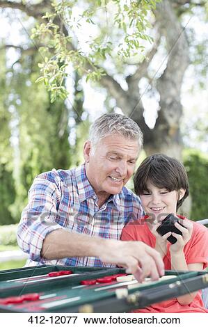 Grandfather and grandson playing backgammon View Large Photo Image Stock Photo - Grandfather and grandson playing backgammon. Fotosearch