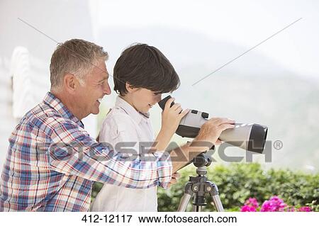 Grandfather and grandson using telescope View Large Photo Image Stock Photo - Grandfather and grandson using telescope. Fotosearch