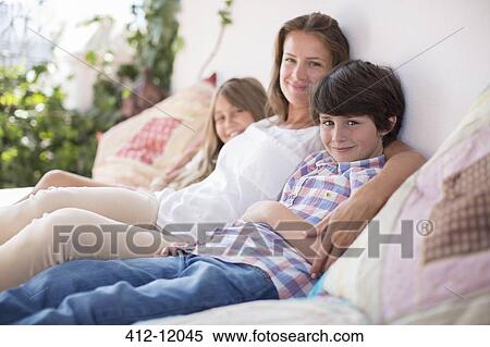 Mother and children relaxing on patio sofa View Large Photo Image Stock Photography - Mother and children relaxing on patio sofa. Fotosearch