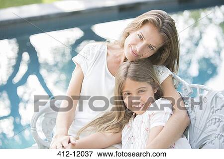 Mother and daughter relaxing at poolside View Large Photo Image Stock Photo - Mother and daughter relaxing at poolside. Fotosearch