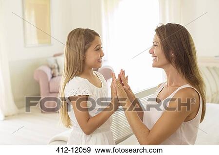 Stock Photo - Mother and daughter touching hands. Fotosearch