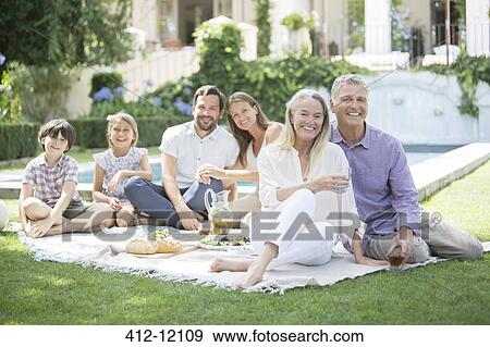 Multi-generation family enjoying picnic in backyard View Large Photo Image Stock Photo - Multi-generation family enjoying picnic in backyard. Fotosearch