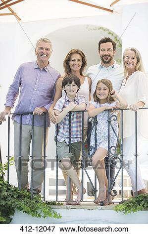 Multi-generation family smiling at balcony railing View Large Photo Image Stock Photo - Multi-generation family smiling at balcony railing. Fotosearch