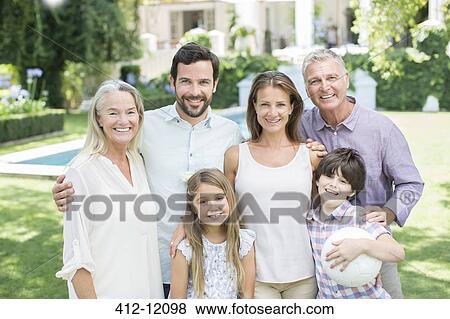 Stock Photo - Multi-generation family smiling in backyard. Fotosearch