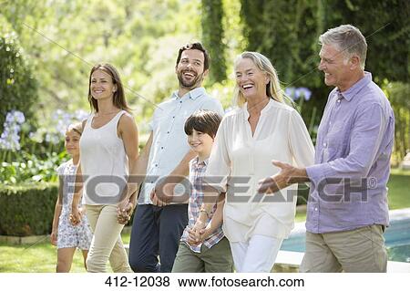 Multi-generation family walking in backyard View Large Photo Image Stock Photo - Multi-generation family walking in backyard. Fotosearch