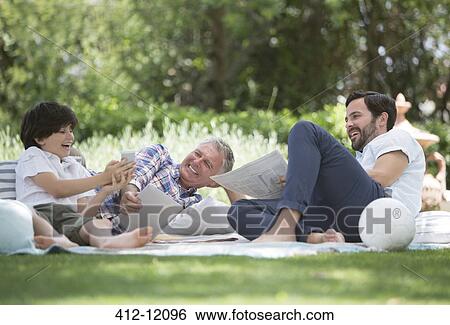 Multi-generation men relaxing on blanket in backyard View Large Photo Image Stock Photograph - Multi-generation men relaxing on blanket in backyard. Fotosearch
