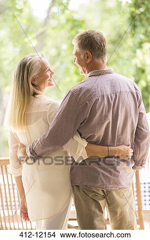 Picture - Senior couple hugging on patio. Fotosearch