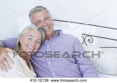 Stock Photo - Senior couple laying on bed. Fotosearch