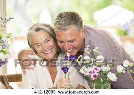 Stock Image - Senior couple smelling flowers. Fotosearch