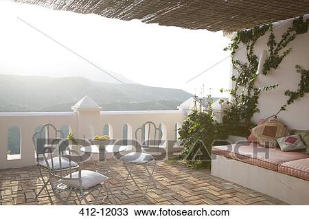 Table and chairs on balcony overlooking mountains View Large Photo Image Stock Image - Table and chairs on balcony overlooking mountains. Fotosearch