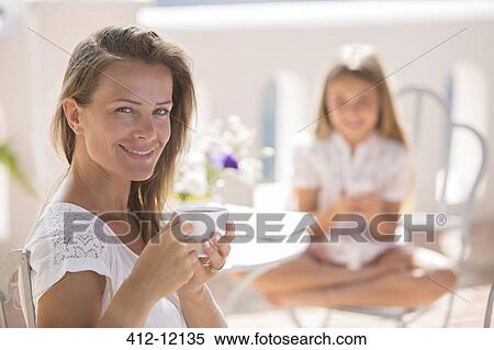 Stock Photography - Woman enjoying cup of coffee outdoors. Fotosearch