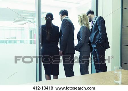 Business people looking out office window View Large Photo Image Stock Photo - Business people looking out office window. Fotosearch