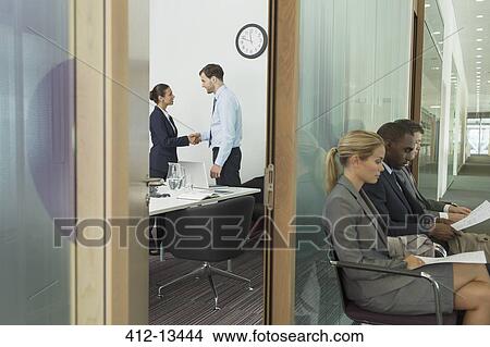 Business people shaking hands in office View Large Photo Image Picture - Business people shaking hands in office. Fotosearch