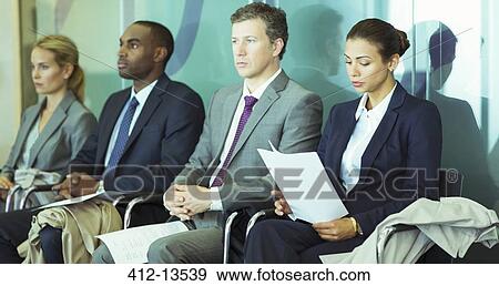 Stock Photo - Business people sitting in waiting area. Fotosearch