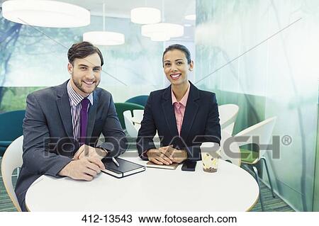 Stock Image - Business people smiling in cafe. Fotosearch