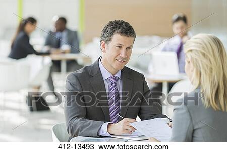 Stock Image - Business people talking in office. Fotosearch