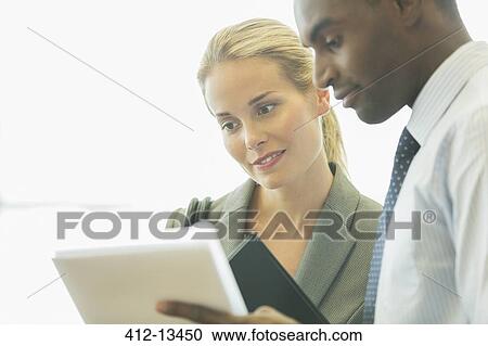 Stock Image - Business people using digital tablet in office. Fotosearch