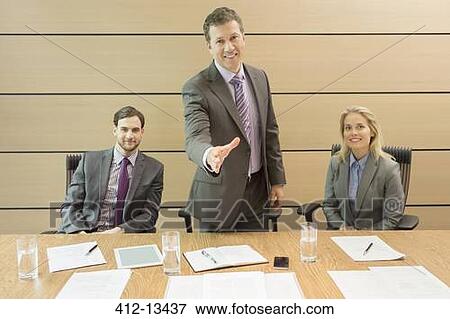 Stock Photo - Businessman extending handshake in meeting. Fotosearch