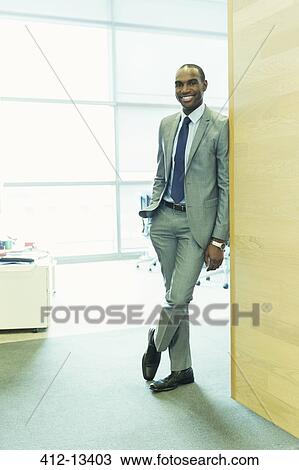 Businessman smiling in office View Large Photo Image Stock Image - Businessman smiling in office. Fotosearch