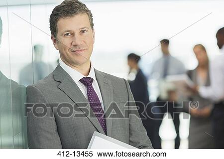 Stock Photography - Businessman smiling in office. Fotosearch