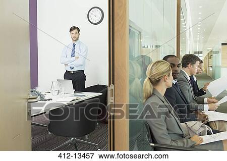 Stock Photo - Businessman standing in office and business people in corridor. Fotosearch