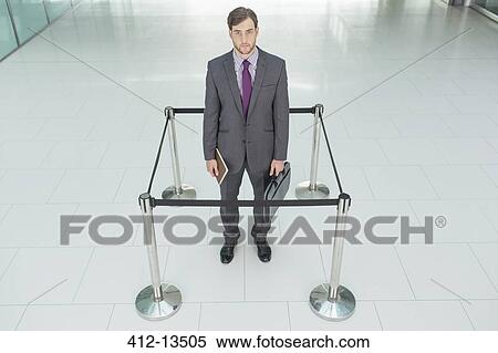 Stock Photography - Businessman standing in roped-off square. Fotosearch
