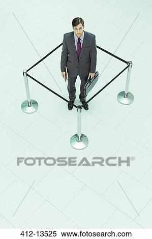 Businessman standing in roped-off square View Large Photo Image Stock Photography - Businessman standing in roped-off square. Fotosearch