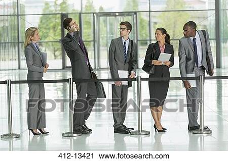Stock Image - Businessman talking on cell phone in line. Fotosearch
