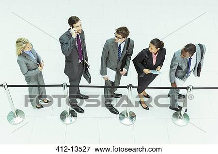 Stock Photo - Businessman talking on cell phone in waiting area. Fotosearch