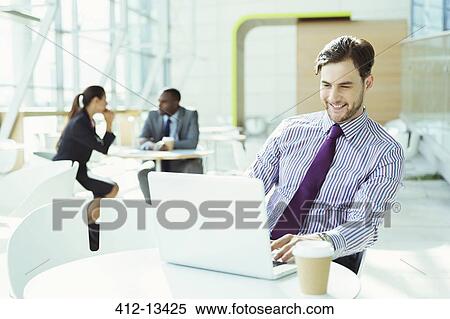 Businessman working on laptop in office View Large Photo Image Stock Photography - Businessman working on laptop in office. Fotosearch