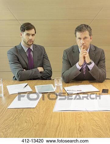Stock Image - Businessmen sitting in meeting. Fotosearch