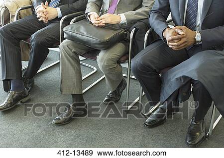 Businessmen sitting in waiting area View Large Photo Image Stock Photo - Businessmen sitting in waiting area. Fotosearch