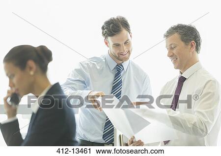 Stock Image - Businessmen talking in office. Fotosearch
