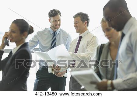 Stock Image - Businessmen talking in office. Fotosearch