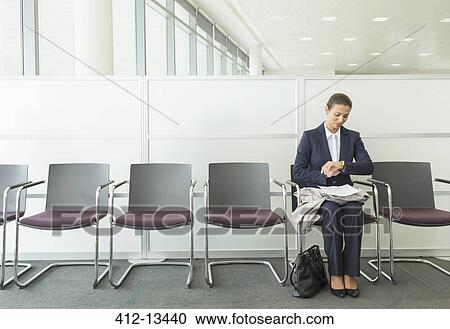 Businesswoman checking wristwatch in office View Large Photo Image Stock Image - Businesswoman checking wristwatch in office. Fotosearch