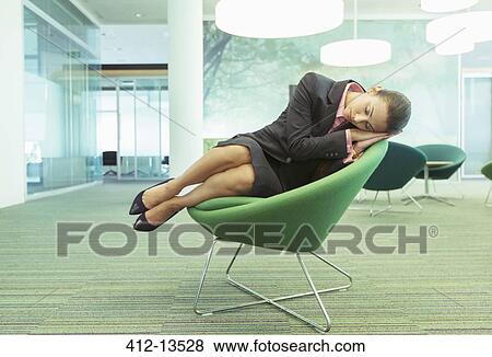 Stock Photo - Businesswoman napping in office chair. Fotosearch