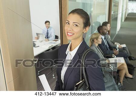 Stock Photo - Businesswoman smiling in office doorway. Fotosearch