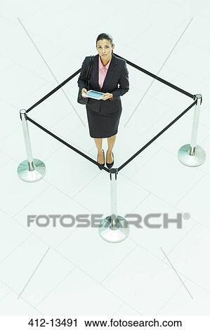 Stock Image - Businesswoman standing in roped-off square. Fotosearch