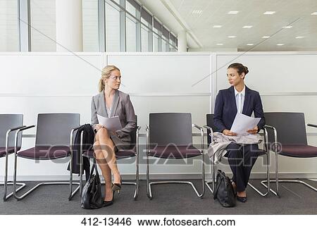 Stock Photograph - Businesswomen sitting in waiting area. Fotosearch