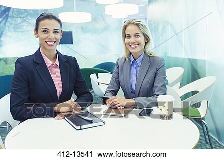Businesswomen smiling in cafe View Large Photo Image Stock Image - Businesswomen smiling in cafe. Fotosearch
