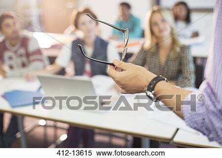 Professor gesturing with eyeglasses in classroom View Large Photo Image Stock Photography - Professor gesturing with eyeglasses in classroom. Fotosearch