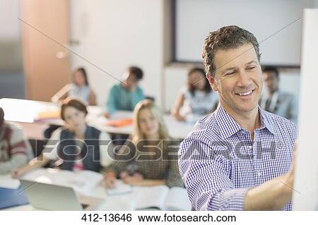 Professor writing on whiteboard in classroom View Large Photo Image Stock Photograph - Professor writing on whiteboard in classroom. Fotosearch