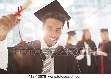 Smiling graduate holding diploma View Large Photo Image Stock Photo - Smiling graduate holding diploma. Fotosearch