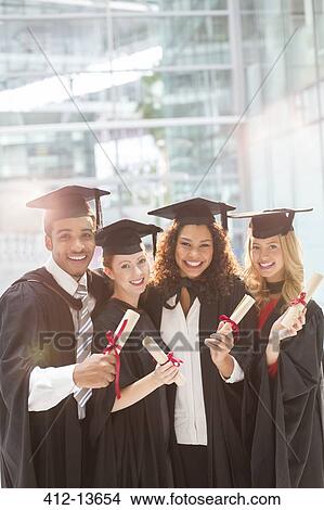 Smiling graduates holding diplomas View Large Photo Image Picture - Smiling graduates holding diplomas. Fotosearch