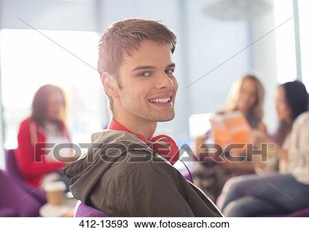 Smiling university student wearing headphones in lounge View Large Photo Image Stock Image - Smiling university student wearing headphones in lounge. Fotosearch