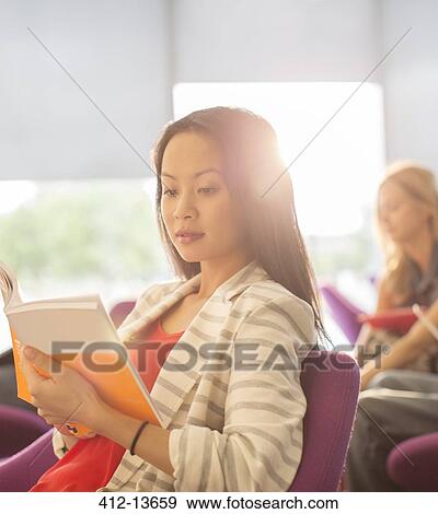 Stock Photo - University student reading in lounge. Fotosearch