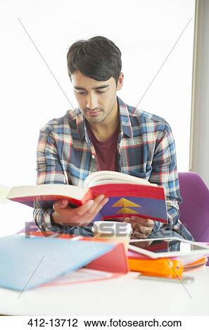 University student reading textbook in lounge View Large Photo Image Stock Image - University student reading textbook in lounge. Fotosearch