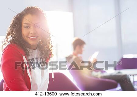 Stock Image - University student smiling in lounge. Fotosearch