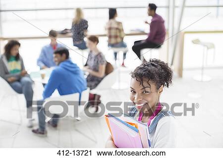 Stock Image - University student smiling in lounge. Fotosearch