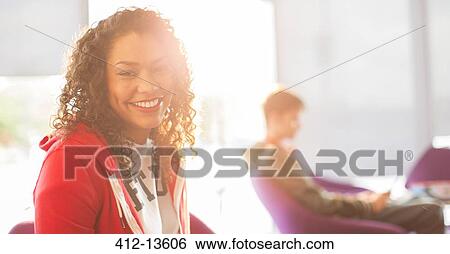 Stock Photograph - University student smiling in sunny lounge. Fotosearch